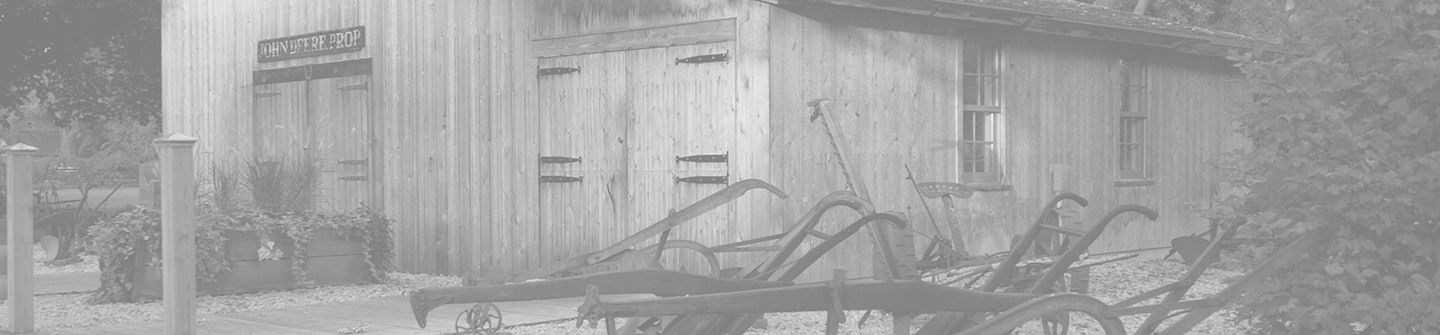 Оцветена черно-бяла снимка на пресъздаването на историческия обект на оригиналния ковашки цех на John Deere на зелен фон
