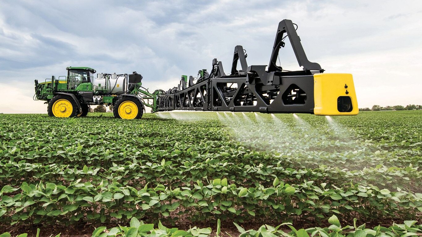 Поглед е близък план на стрелата на пръскачка John Deere в открито поле.