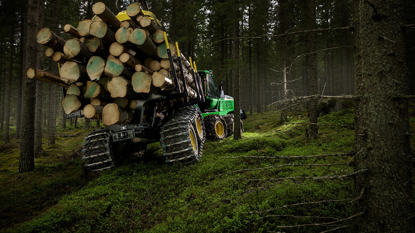 Транспортьорът John Deere 1510G пренася трупи в гората