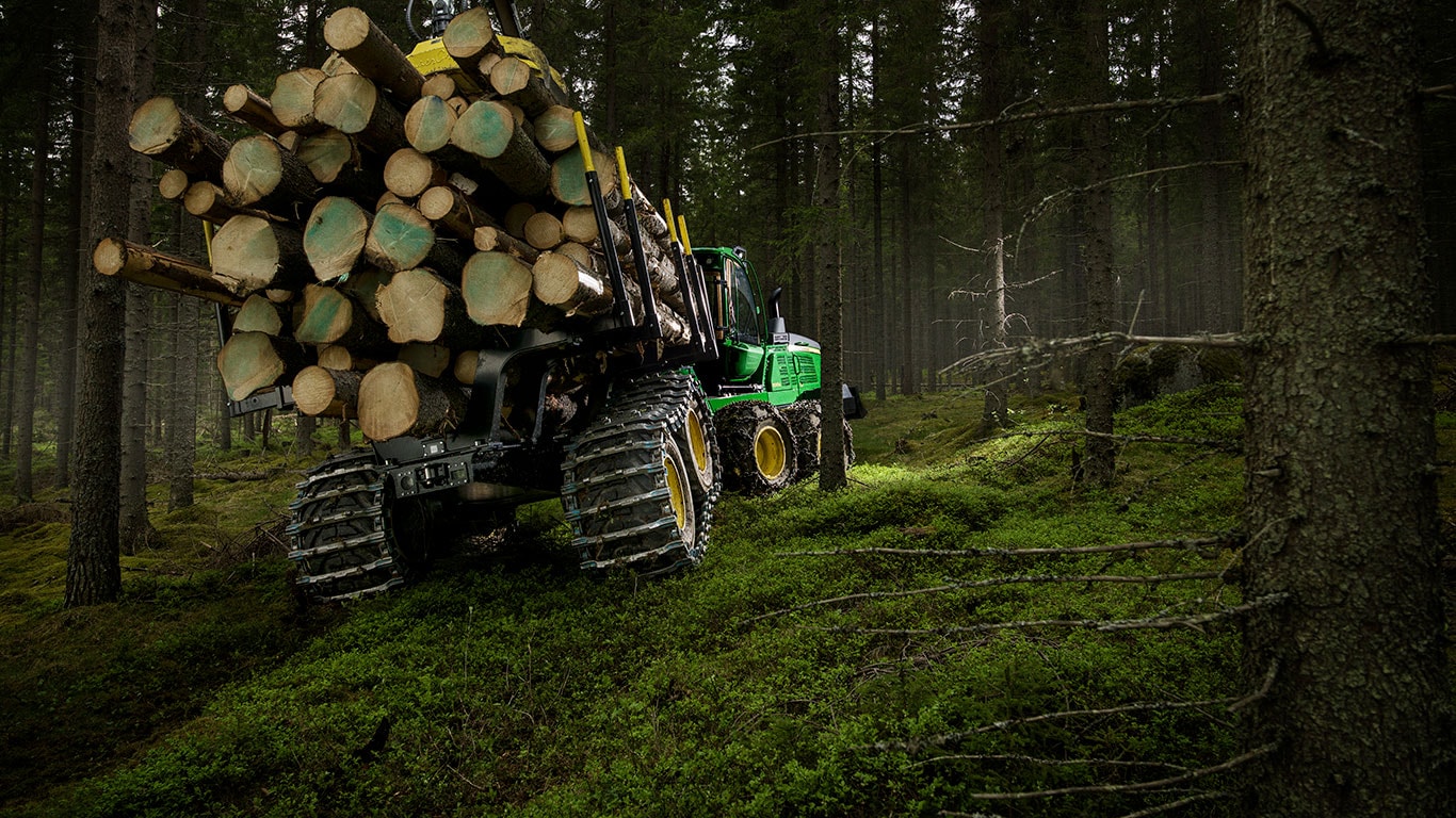 Транспортьорът John Deere 1510G пренася трупи в гората