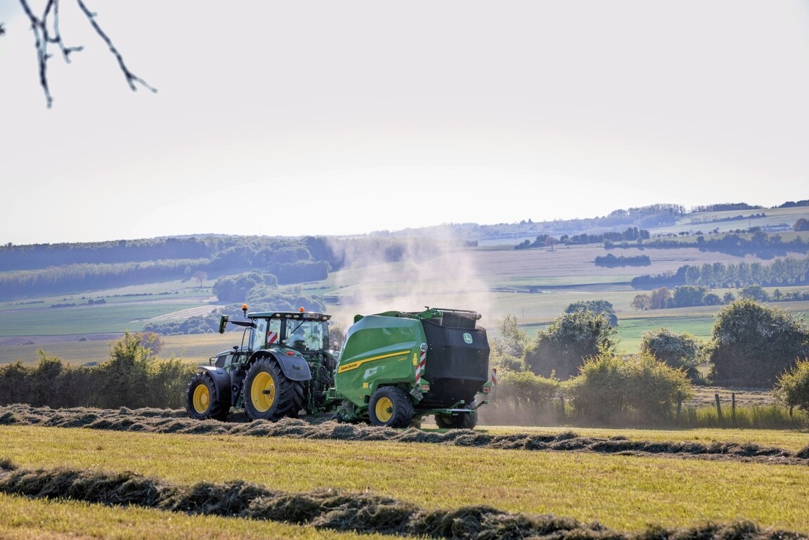 John Deere V462R, теглен от трактор John Deere 6R 185, балиращ сено