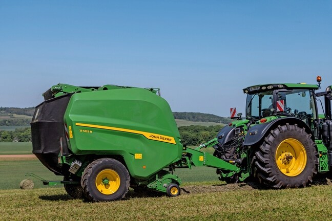 John Deere V462R, теглен от трактор John Deere 6R 185, балиращ сено